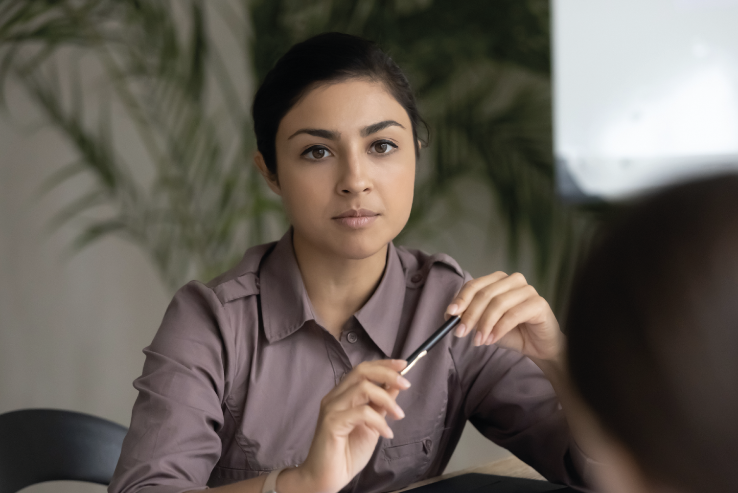 Young Asian woman considers her options at the negotiation table